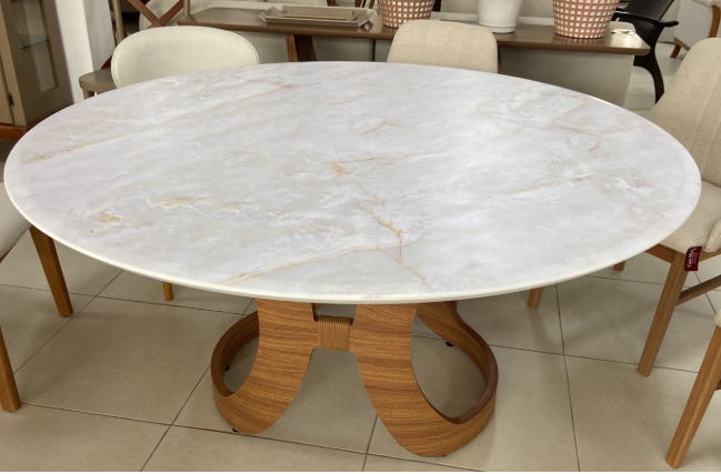 Mesa de jantar redonda com tampo branco marmorizado e base central em madeira