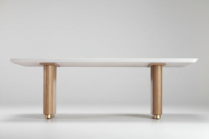 Mesa de jantar com tampo de vidro branco e base de madeira em quatro pés.